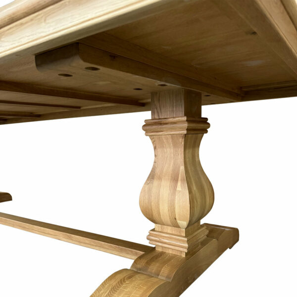 Close-up of an oak table leg with ornate turning, joined to the underside of a Antique French Style Solid Wood Extra Long Dining Table Outdoor Picnic Plus Long Table, shown against a white background.