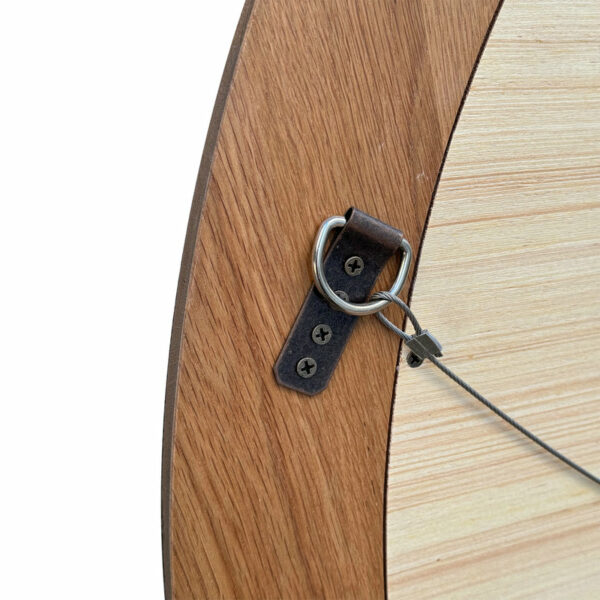 Close-up of a security cable lock attached to a French Country Style Midcentury Furniture Antique Oak Large Natural Wood Round Wood Framed Mirror, secured with a metal bracket and screws.