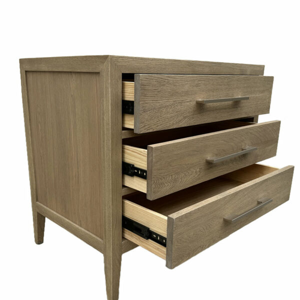 A Luxury Contemporary Bedroom Furniture Extended Chest of Drawers with two partially open drawers revealing books stored inside, adjacent to a three drawer closed nightstand.