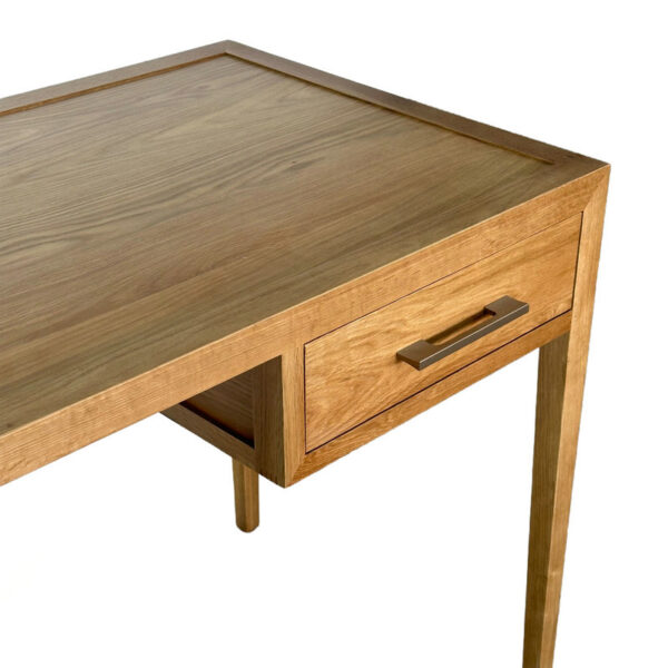 A modern oak dressing table with a rectangular top, tapered legs, and a right-side drawer with a metal handle.