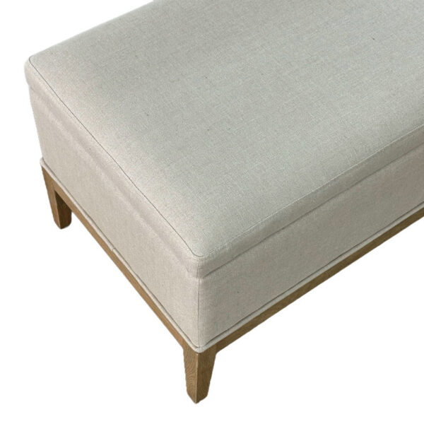 The Nordic Luxury Upholstered Bench, with beige fabric and a solid wood frame, is elegantly displayed from a slightly elevated angle.