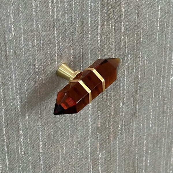 Close-up of a brass knob with dark amber glass on the Luxury Modern Gray Shagreen Nightstand.