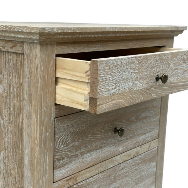 Close-up of a 3-drawer oak bedside cabinet with dovetail joints, light weathered finish, and bronze knobs. One drawer is partially open.