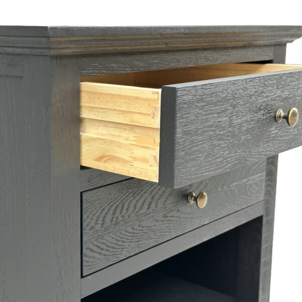 Close-up of a dark grey French antique oak nightstand with two drawers (one partially open) and round metal knobs.