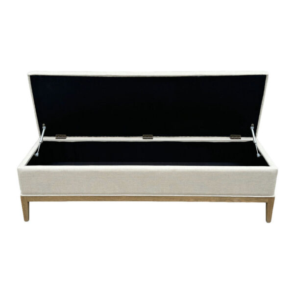 The Linen Upholstery Ottoman, with a wooden base and black interior, doubles as an elegant footrest or storage bench.