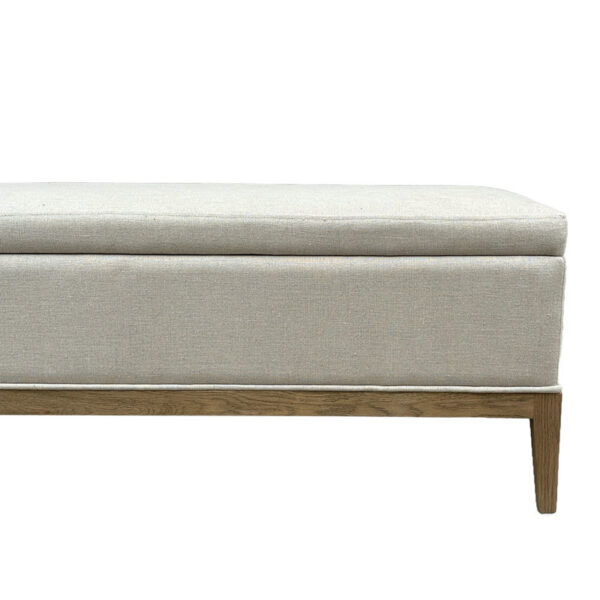 The Natural Linen Rectangular Ottoman is a stylish light gray bench with wooden legs, ideal as a footrest.