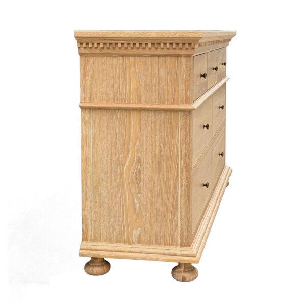 Side view of a French Antique Solid Wood 7-Drawer Dresser with intricate trim, rounded legs, and a light wood finish.