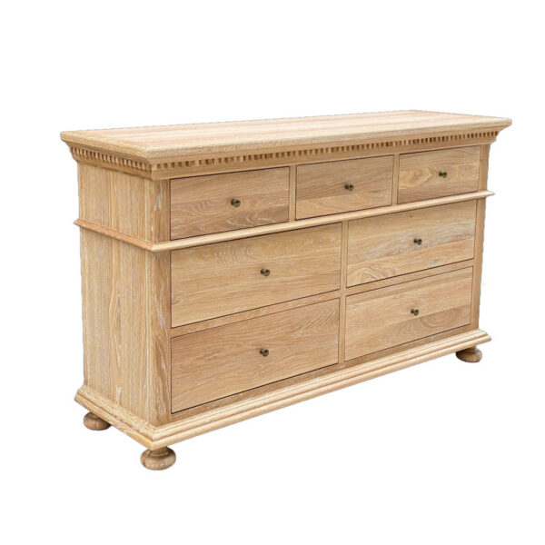 The French Antique Solid Wood Dresser has seven drawers, with round handles, and rests on rounded feet.