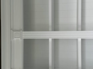 Teto artesoado branco com painéis e vigas rebaixadas, com estante branca estilo Dundee French Provincial.