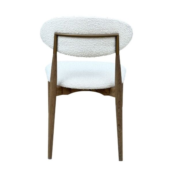 Una silla de madera con patas en ángulo y asiento y respaldo con textura blanca, mostrada desde atrás.