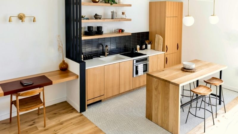 Bright, airy kitchen featuring sleek wood cabinetry, open shelves, and cozy dining area with bar stools, perfect for contemporary home styling and functional living spaces.