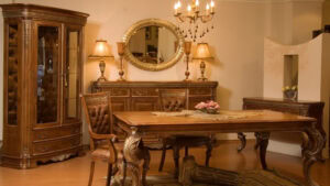 Vintage-inspired wooden dining table with ornate carved legs and matching chairs, complemented by antique sideboard and display cabinet in a classic, cozy interior.