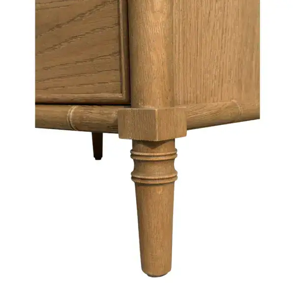 Close-up of a wooden bedside table featuring three drawers and tapered legs, ideal for bedroom storage and decor.